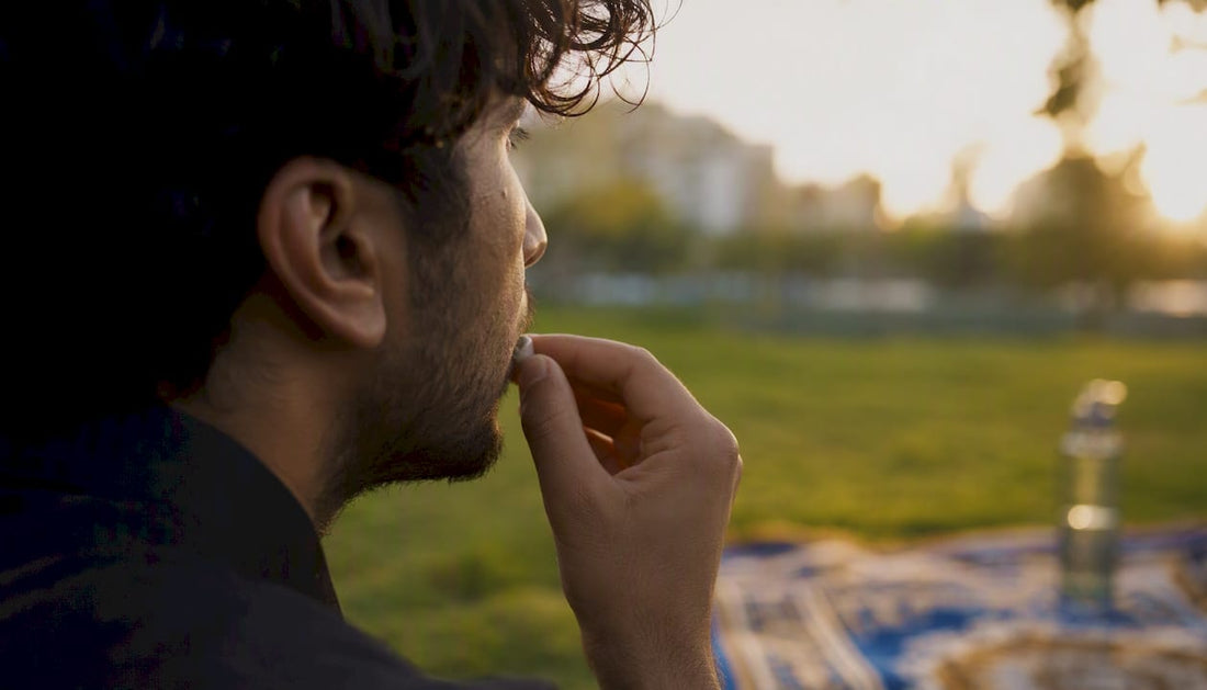 Hand placing nicotine pouch under lip outdoors