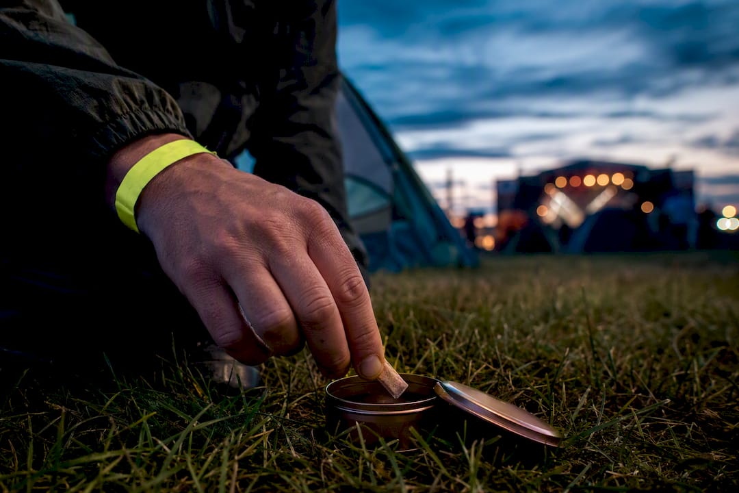 Adult festival-goer securing used pouch tin