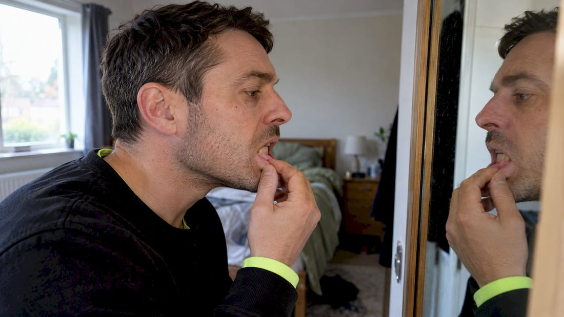 Adult checking mild gum irritation in mirror