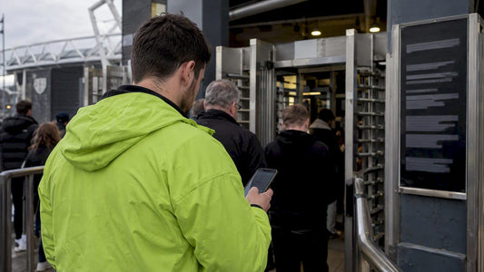 Fan checks entry rules before stadium turnstiles